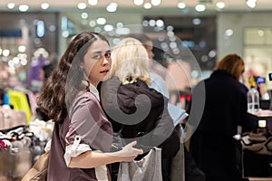 Black friday. Portrait of young Caucasian woman looking back and standing in store queue to pay for purchase. Concept of