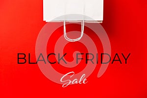 Black Friday sale. Blank white paper bag isolated on red background. Discount, recycling, shopping and ecology concept