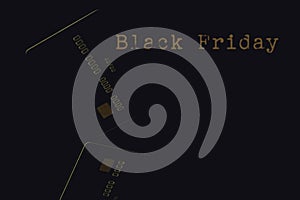 Black friday sale concept. Credit card  with grange gold colour text close up on Black monochromatic background