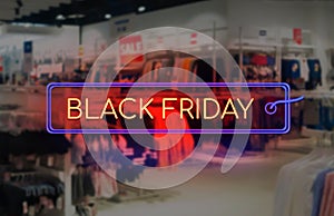 Black Friday sale neon sign. Blurred stop interior as a background. Seasonally sale, shopping and store concept