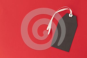 Black Friday sale tag with white ribbon on red background. Black Friday concept.