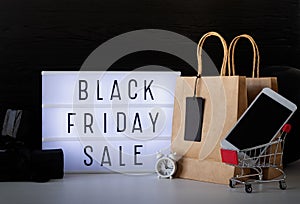 Black friday Sale words on lightbox with black price tag and gifts front view on dark background