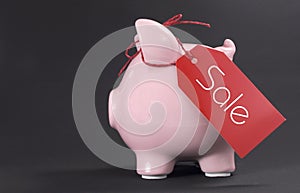 Black Friday shopping sale concept with red ticket Sale tag hanging from piggy bank
