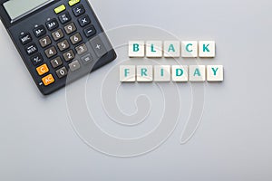 Black friday text and calculator on gray background. Top view