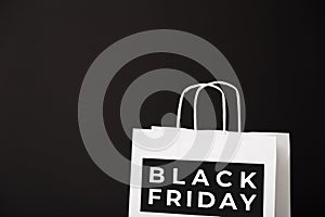 Black Friday white paper bag isolated on black background. Black friday, sale, discount, recycling, shopping and ecology