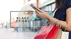 Black Friday, Woman using smartphone carrying shopping bags