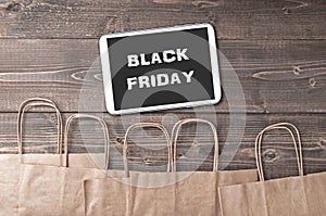 Black friday words on tablet pc and craft shopping bags