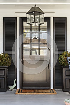 Black front door to a family home with porch