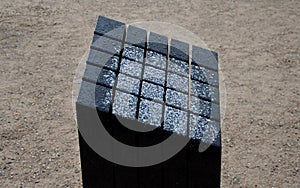 Black gabbro stone prism. it stands in the park and is bevelled and polished. if it gets wet, can play various sound melodies and