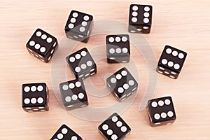 Black game dice showing the six on all face.Many cubes for board games on light background.Selective focus.Concept of victory,