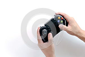 A Black game joystick console controller in gamer hands.Game controller in hand isolated on white background