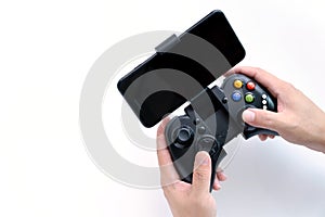 Black gaming joystick with smartphone installed into holder in gamer hands, with blank black screen, Game controller in hand ,