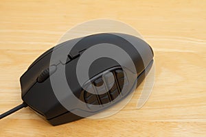 Black gaming mouse on a wood desk