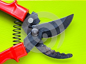 Black garden pruner with red handles