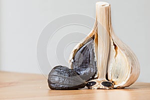Black garlic close up shot with cloves and whole garlic.