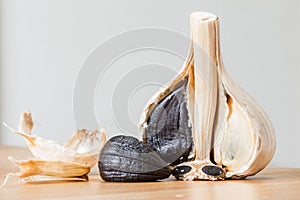 Black garlic close up shot with cloves and whole garlic.