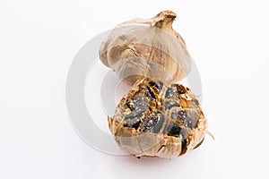 Black garlic cloves isolated on white background