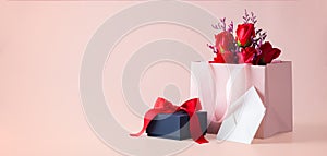 Black gift box and paper bag with rose and white card in envelope, valentines day background