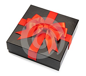 black gift box with red satin ribbon and bow on white background