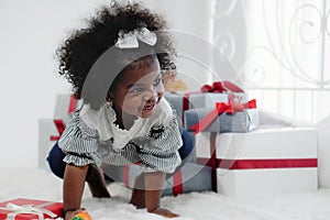 Black girl child playing toy from present box in white room