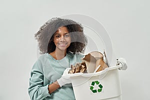 Black girl holding dustbin with cardboard garbage