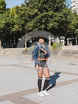 Black girl holding roller skates