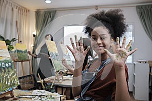 Black girl`s hand messed up with acrylic colors, happy learning in art studio