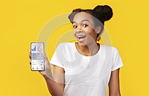 Black Girl Showing Smartphone With Physical Activity Application, Yellow Background