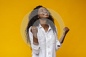 Black girl smiling and raising clenched fists in the air