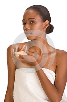 Black girl with soap bar in white bath towel