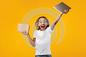 Black girl standing with book and tablet in studio