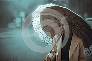 Black girl with umbrella in the fog