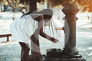 Black girl is using street washbasin