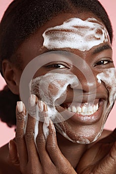 Black girl wash face with cleansing face foam