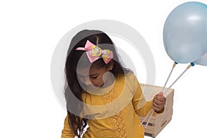 Black girl in yellow shirt playing, photo with white background. child playing with balloon isolated