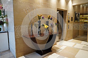 Black and Glass vases with flowers inside are put on the antique table for interior decoration in a hotel lobby. Theyâ€™re