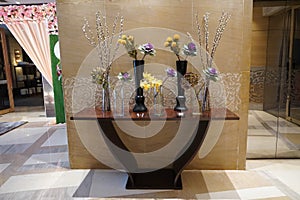 Black and Glass vases with flowers inside are put on the antique table for interior decoration in a hotel lobby. Theyâ€™re