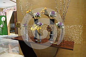 Black and Glass vases with flowers inside are put on the antique table for interior decoration in a hotel lobby. Theyâ€™re