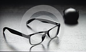 Black glasses and a computer mouse are on the table