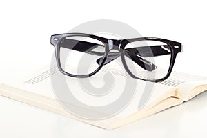 Black glasses on open book