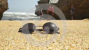 Black glasses on white sand