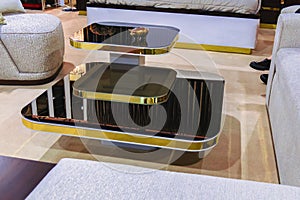 Black glossy coffee table with a gold border in the interior of the room