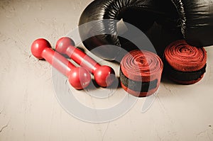 black gloves and red dumbbells and bandage/boxing concept with black gloves and red dumbbells and bandage