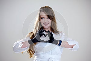 black gloves white clothes backlight smart watch woman with medical mask and hands shows the symbol of the heart. Doctor