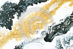 Black and gold acrylic pour paint technique on a canvas for a background image as a web graphic