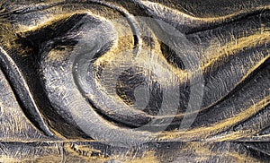Black and gold painted carved wood swirl design texture