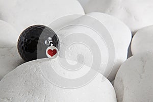 Black golf ball and red heart