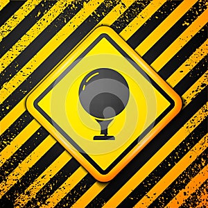 Black Golf ball on tee icon isolated on yellow background. Warning sign. Vector Illustration