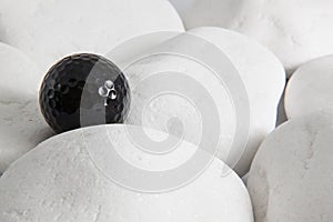 Black golf ball and white stones