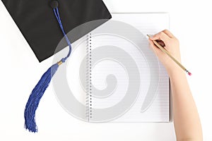 Black graduation cap with notebook isolated
